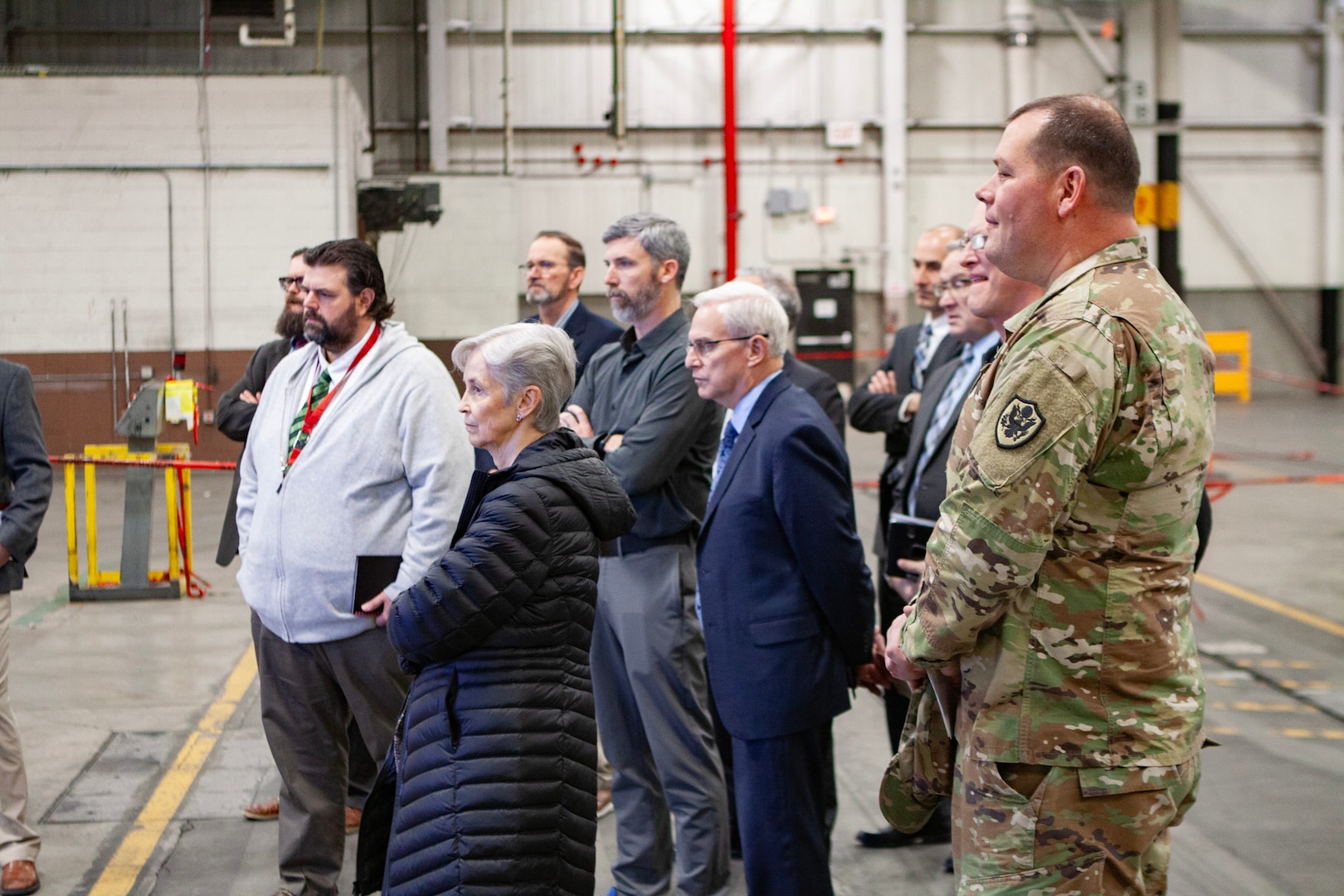 A group of people standing in a warehouse.
