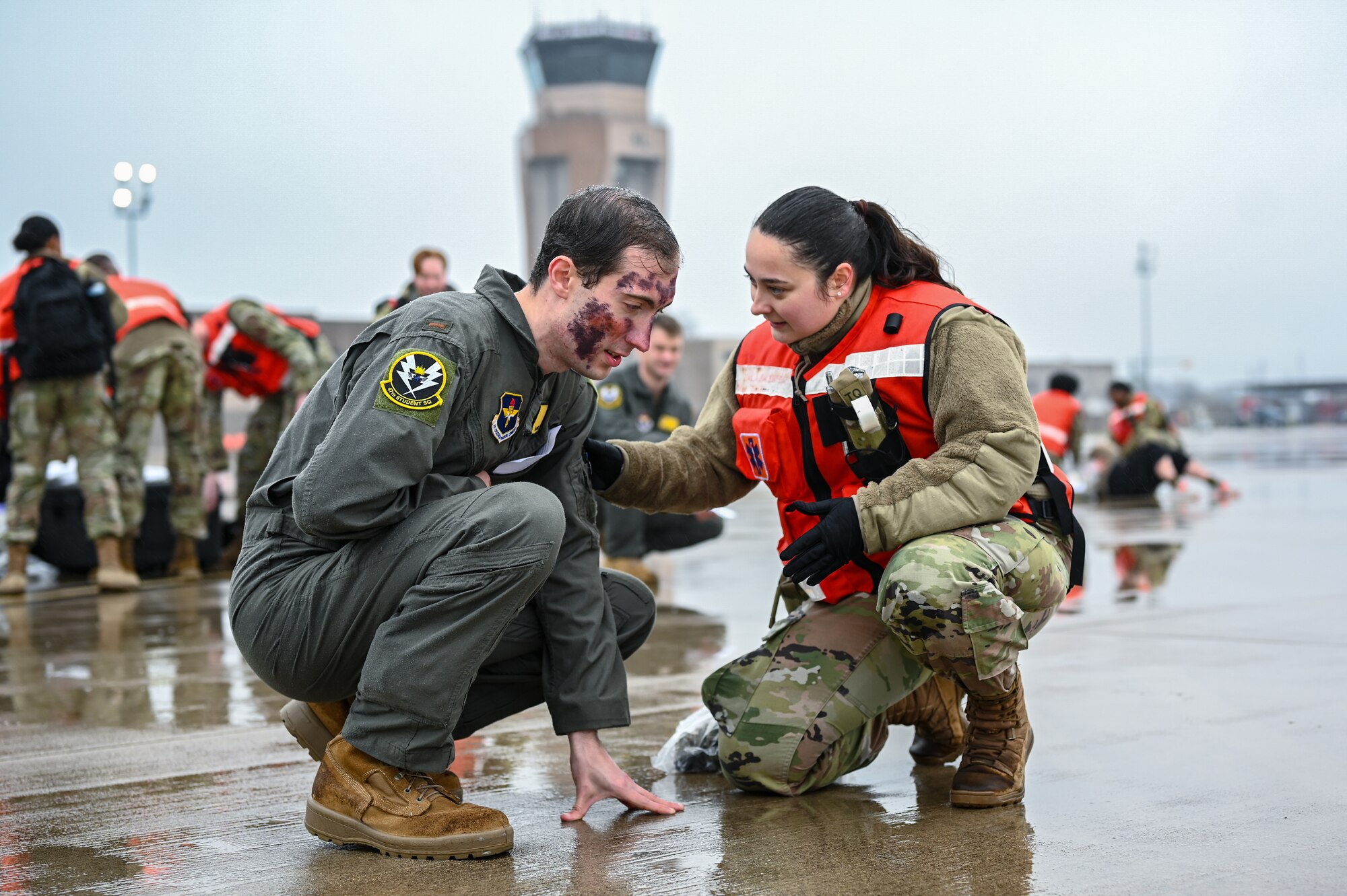 U.S. Air Force 2nd Lt. James Harding (left), 47th Student Squadron student pilot, answers exercise medical questions from Senior Airman Madison Vega (right), 47th Medical Group family medicine technician, during a Major Accident Response Exercise (MARE) on the flight line at Laughlin Air Force Base, Texas, Dec. 14, 2023.