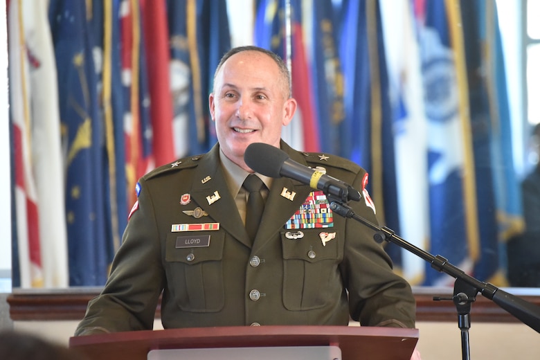 A man in an Army uniform stands at a podium.