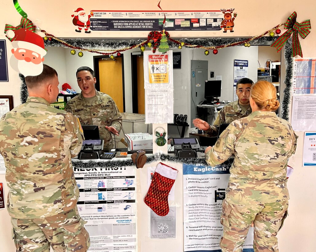 Spc. Gabriel Ezrilov (left), a financial clerk with the 909th HR Co. (Postal), speaks with a customer at the front window of the Soto Cano Post Office on Soto Cano Air Base near Comayagua, Honduras. The unit just kicked off a 9-month deployment providing postal operations at the air base.