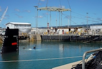 A Pearl Harbor Naval Shipyard & Intermediate Maintenance Facility diver directs rigging equipment into the water during the undocking of the Virginia-class attack submarine USS Minnesota (SSN 783) from Dry Dock 2, Oct. 12, 2023.