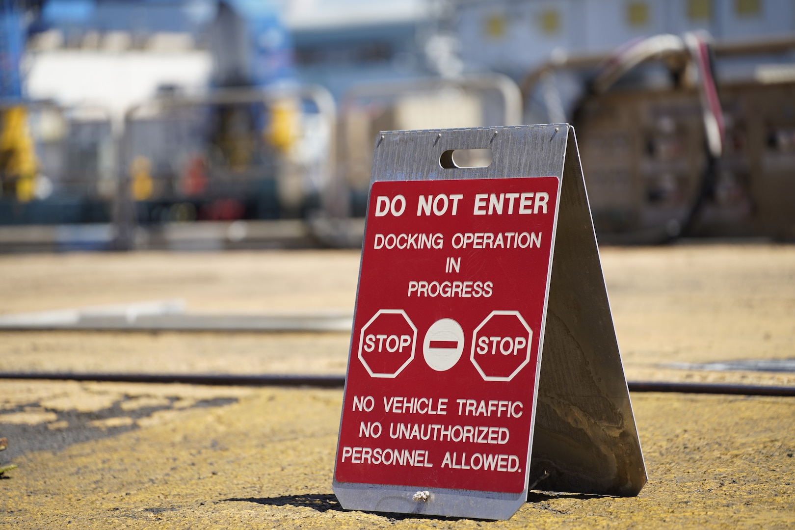 A safety sign notifies Pearl Harbor Naval Shipyard & Intermediate Maintenance Facility personnel of active operations during the undocking of the Virginia-class attack submarine USS Minnesota (SSN 783) from Dry Dock 2, Oct. 12, 2023.