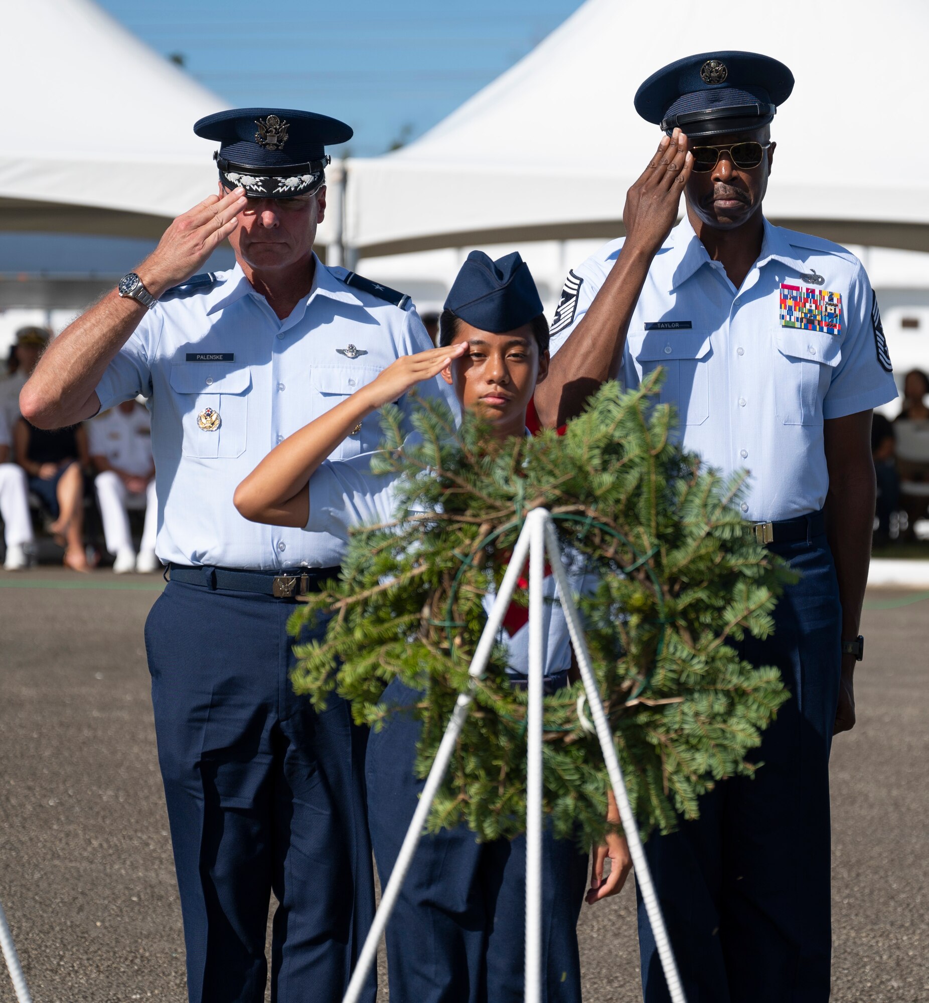 U.S. Air Force Brig. Gen. Thomas Palenske, 36th Wing commander, Chief Master Sgt. Nicholas Taylor, 36th Wing command chief, and a member of the junior reserve officer training corps salute a wreath during the Wreaths Across America ceremony at the Guam Veterans Cemetery, Guam, Dec. 16, 2023. The Wreaths Across America program allows families to honor and remember the sacrifices of our military Veterans by placing wreaths on their graves during the holiday season. (U.S. Air Force photo by Airman 1st Class Spencer Perkins)