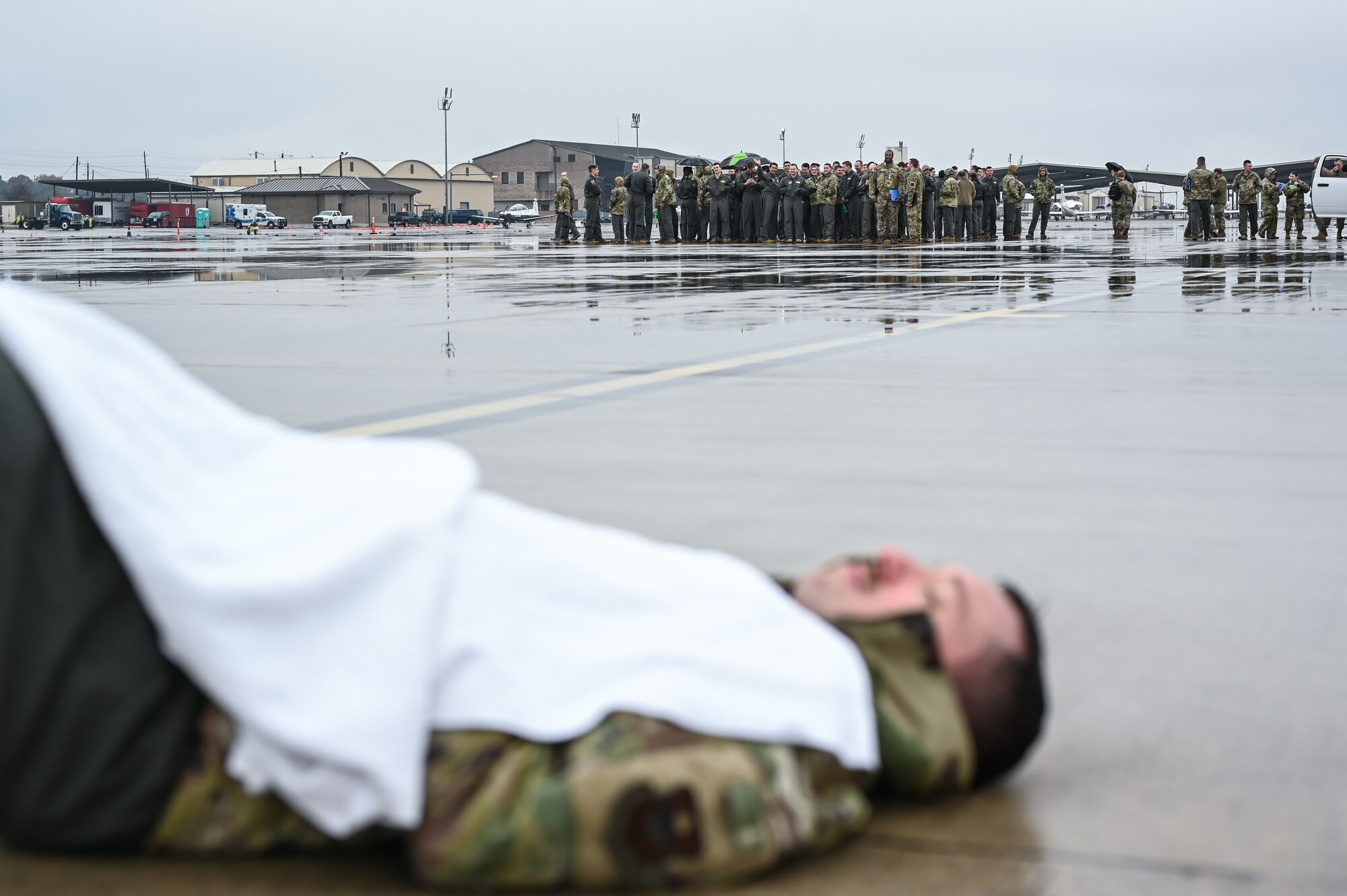 U.S. Air Force Airmen from the 47th Student Squadron, simulating an air show crowd, witness an exercise casualty body from afar during a Major Accident Response Exercise (MARE) on the flight line at Laughlin Air Force Base, Texas, Dec. 14, 2023.