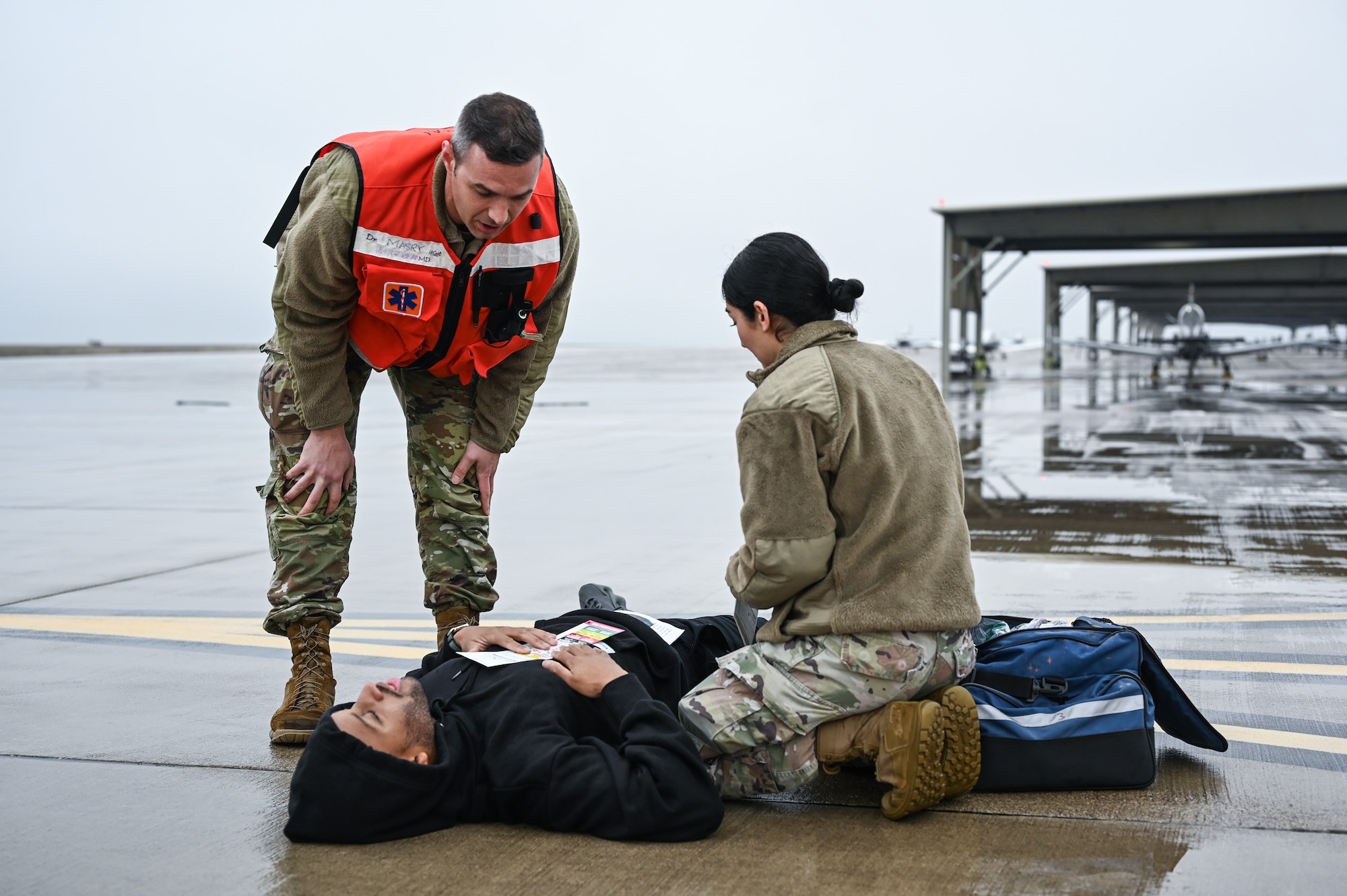 U.S. Air Force Capt. Colin Sulpizio (left), 47th Medical Group family physician, and Airman Veronica Perez (right), 47th MDG outpatient records technician, treat a simulated injured person during a Major Accident Response Exercise (MARE) on the flight line at Laughlin Air Force Base, Texas, Dec. 14, 2023