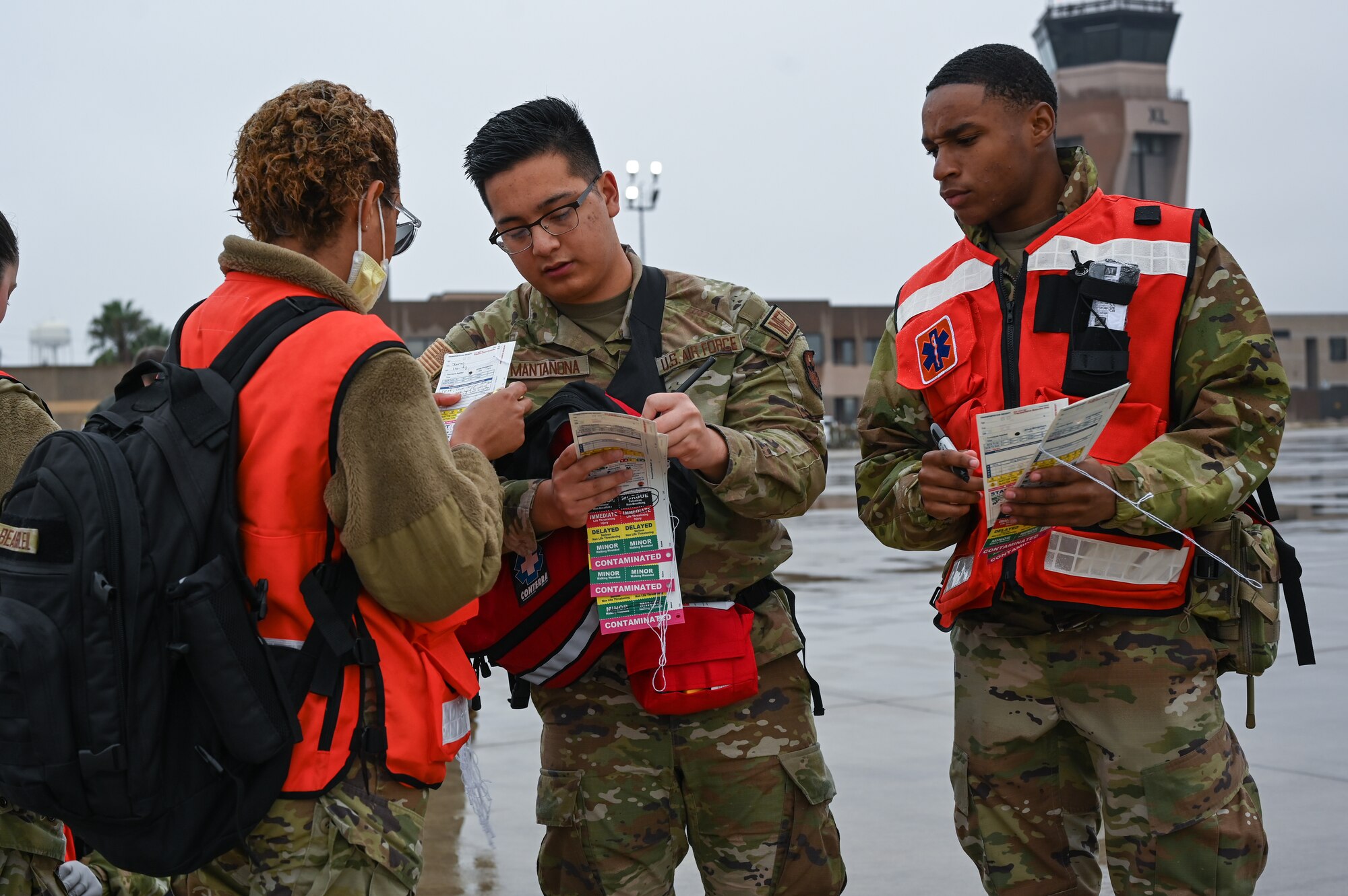U.S. Air Force Airman 1st Class Ashley Beausoleil (left), 47th Medical Group health services management, Senior Airman Rico Mantanona (middle), 47 MDG health services management, and Senior Airman Dakamien Brown (left), 47 MDG referral management technician, compare patient injury cards during a Major Accident Response Exercise (MARE) on the flight line at Laughlin Air Force Base, Texas, Dec. 14, 2023