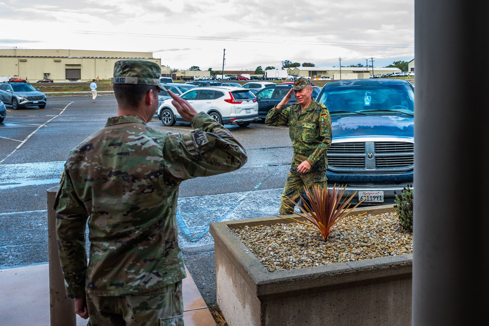 A military man in uniform salutes another military man.