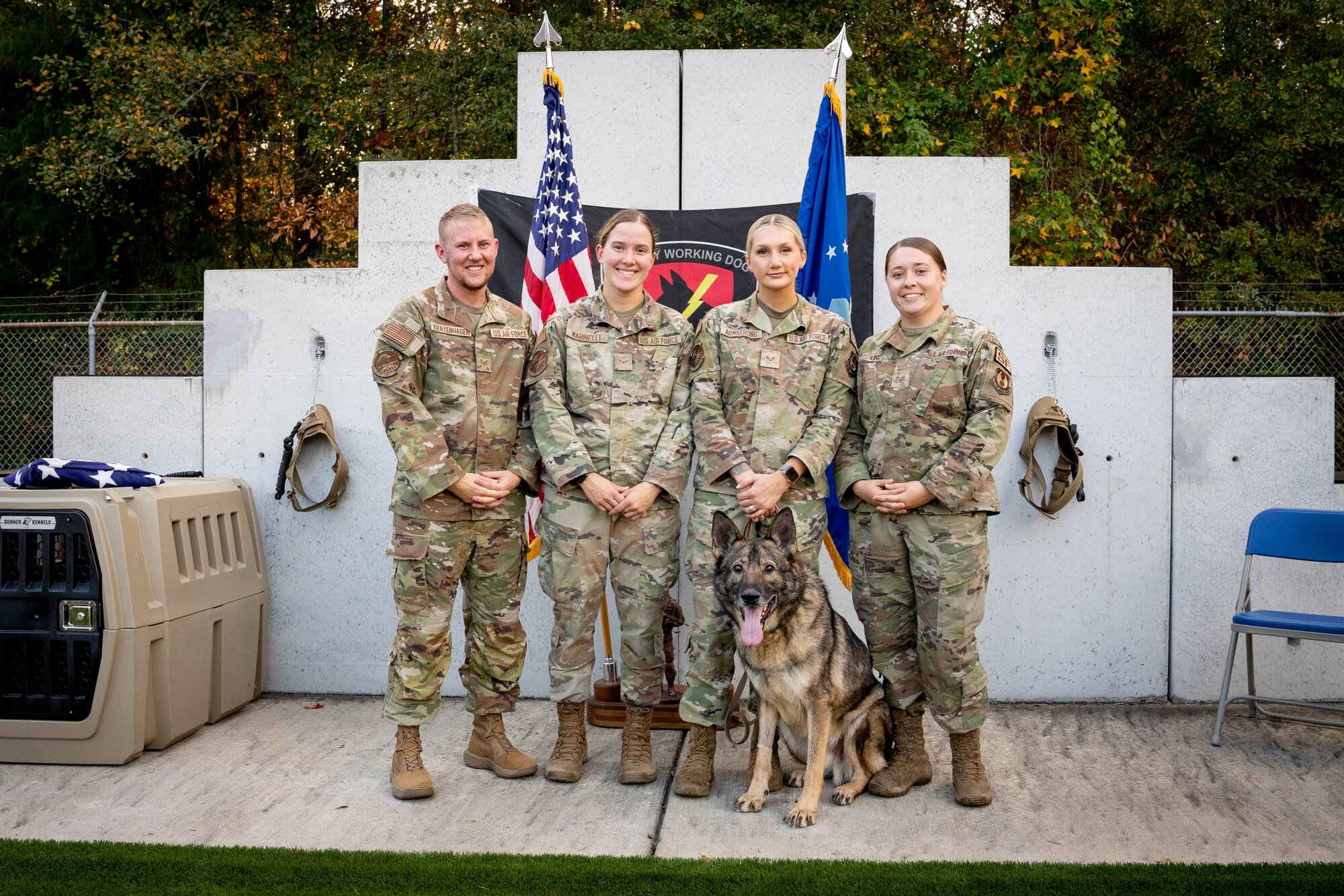 Airmen taking picture with dog