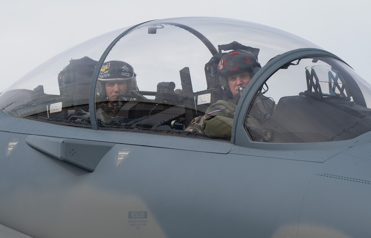 Two pilots sit in the cockpit of a F-15EX Eagle aircraft.