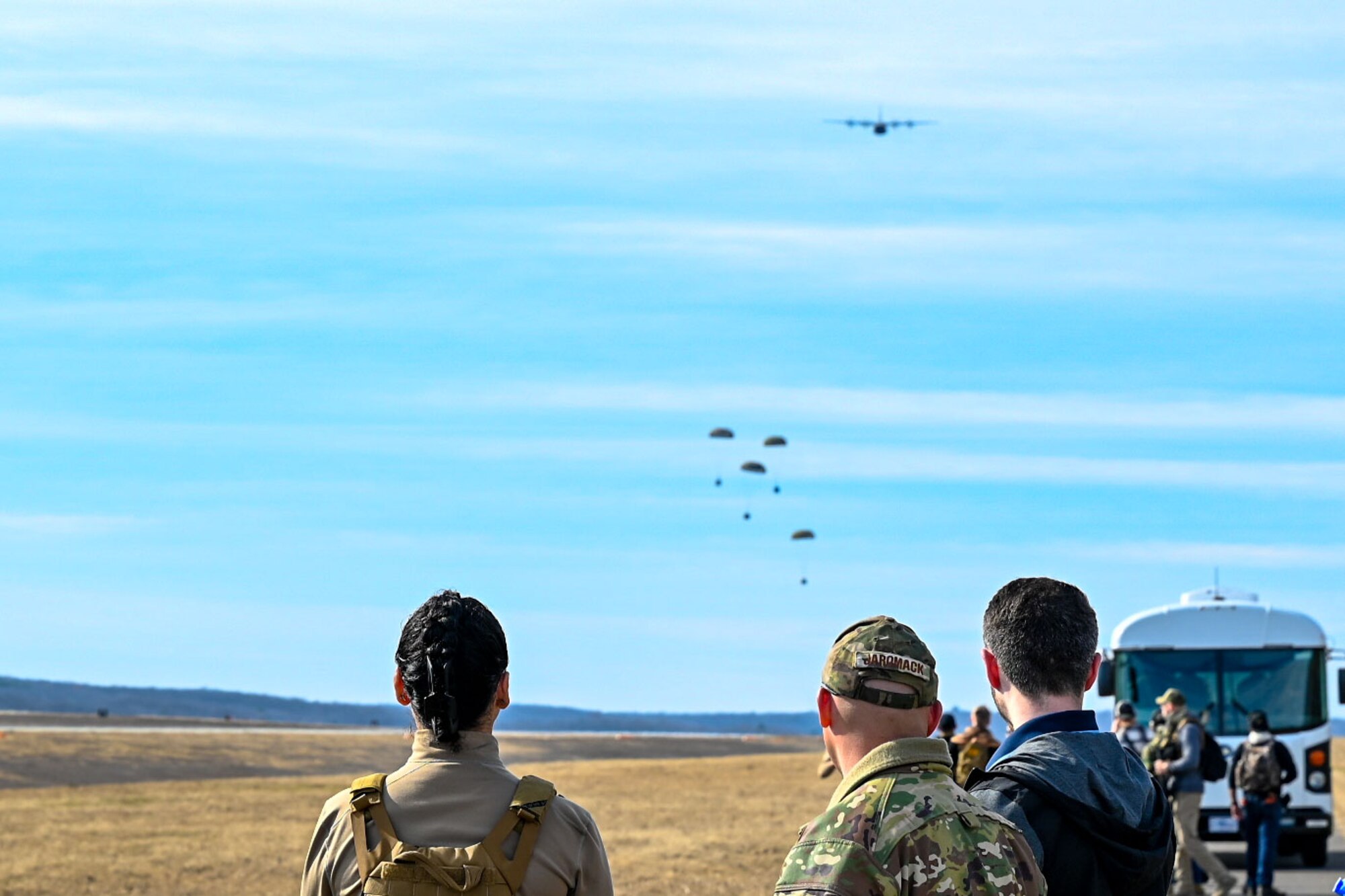 Team Little Rock Airmen watch as four cargo crates drop from a C-130J Super Hercules as part of a Warrior Airmen Readiness Center capstone event