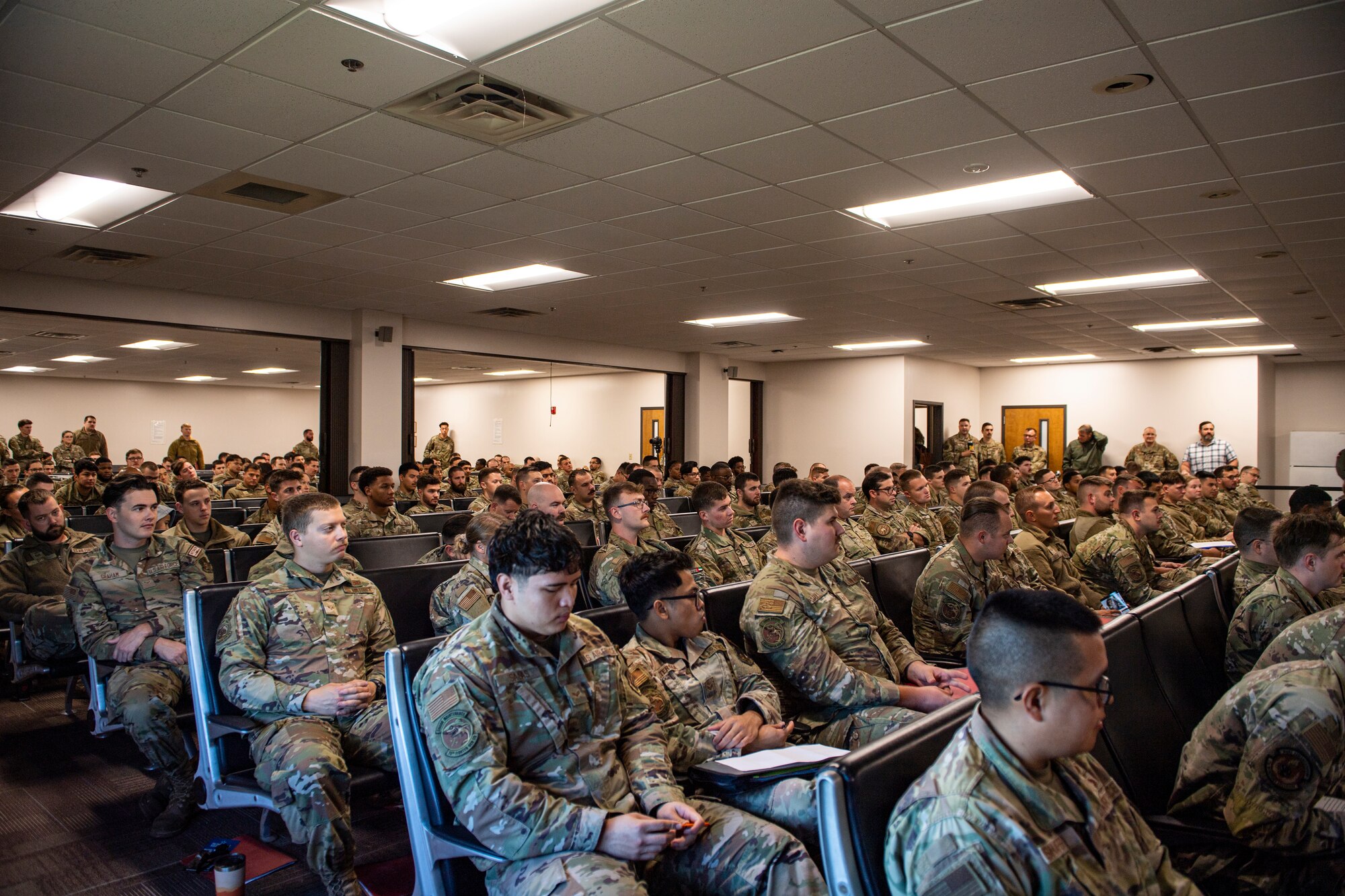 Airmen listen to briefers after returning home from deployment