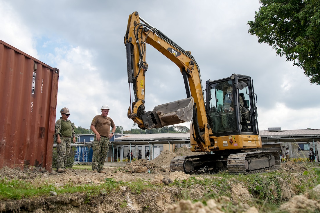 U.S. Navy Equipment Operator 3rd Class Yue Zhao, from Los Angeles, Chief Equipment Operator Christian Ransomer, from Dayton, Ohio, and Construction Mechanic Constructionman Apprentice Austin Loller, from Fort Smith, Arkansas, dig a trench with an excavator at the National Referral Hospital in Honiara, Solomon Islands, during Pacific Partnership 2024-1, Nov. 22, 2023.
