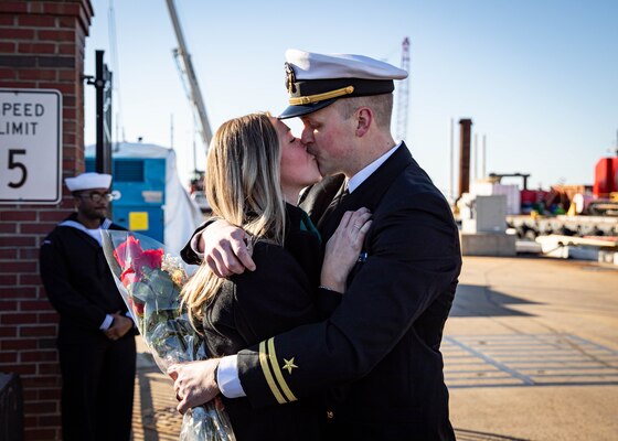 Lt. Jacob Magnusson, assigned to the Virginia-class fast-attack submarine USS Washington (SSN 787), kisses his significant other during the boat’s homecoming at Naval Station Norfolk, Dec. 15, 2023.