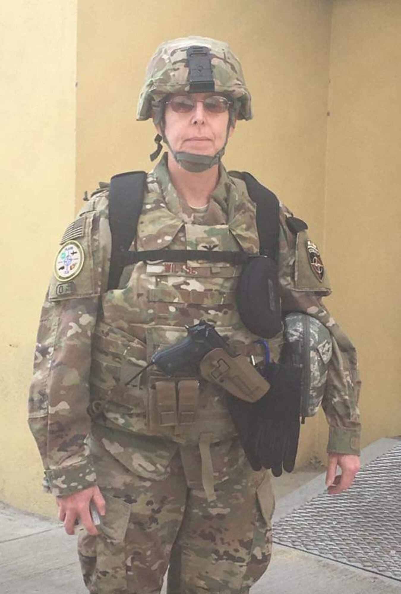 Gretchen Wiltse, in an OCP uniform with protective gear and helmet, poses for a photo.