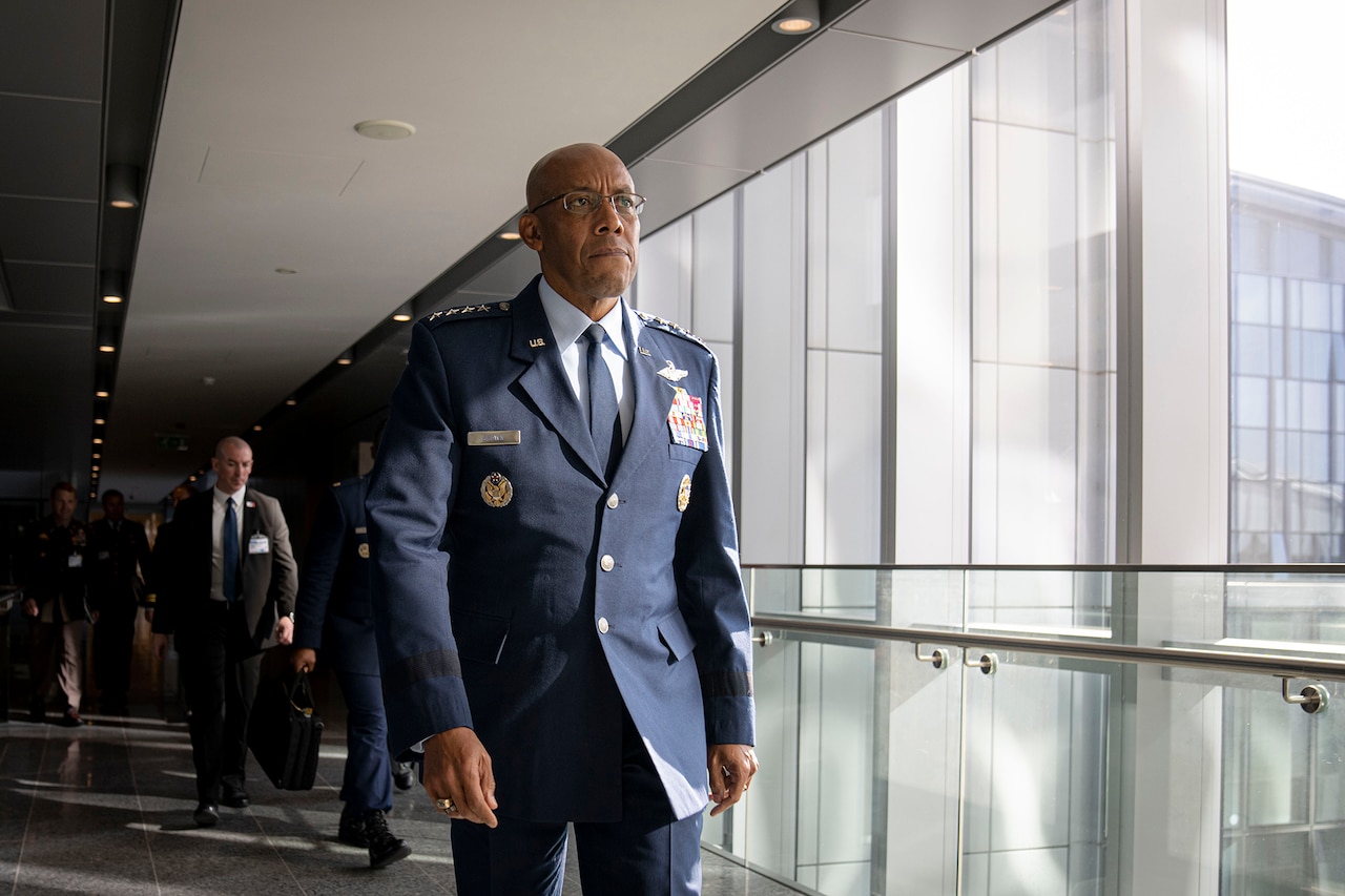 A person in uniform walks down a corridor.