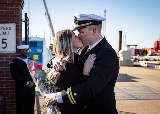 Lt. Jacob Magnusson, assigned to the Virginia-class fast-attack submarine USS Washington (SSN 787), kisses his significant other during the boat’s homecoming at Naval Station Norfolk, Dec. 15, 2023.