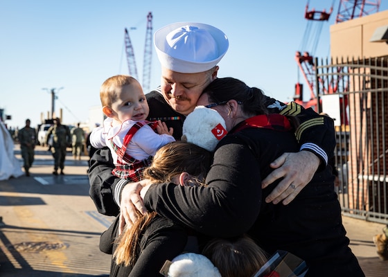 Information Systems Technician (Submarine) 1st Class Macon Kirk, assigned to the Virginia-class fast-attack submarine USS Washington (SSN 787), embraces his family during the boat’s homecoming at Naval Station Norfolk, Dec. 15, 2023.