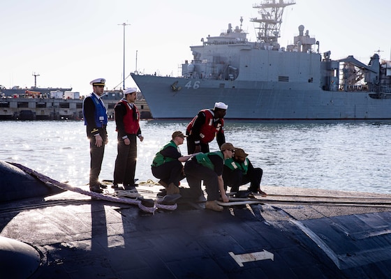 Sailors aboard the Virginia-class fast-attack submarine USS Washington (SSN 787) heave line as the boat moors pierside during its homecoming at Naval Station Norfolk, Dec. 15, 2023.