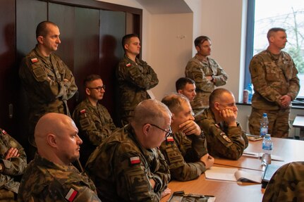 Polish soldiers and U.S. soldiers listen to a briefing in Warsaw, Poland, Dec. 14, 2023. The first Warfighting Symposium was held to start a continuous dialogue on military tactics to create interoperability between the U.S., Poland and other NATO forces. (U.S. Army Reserve photo by Sgt. Peter Martinez)