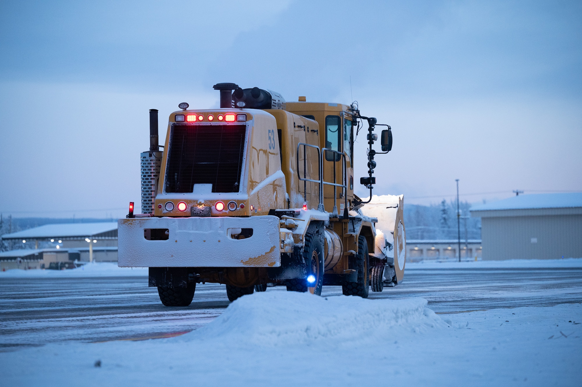 A snow blower operator, from the 354th Civil Engineering Squadron, stands by before clearing snow off the flight line on Eielson Air Force Base, Alaska, Dec. 19, 2023. The snowplow operators run 24/7 shifts to ensure the flight line is clear to deploy aircraft in support of Pacific Air Forces and United States Indo-Pacific Command missions. (U.S. Air Force Photos by Airman Spencer Hanson)