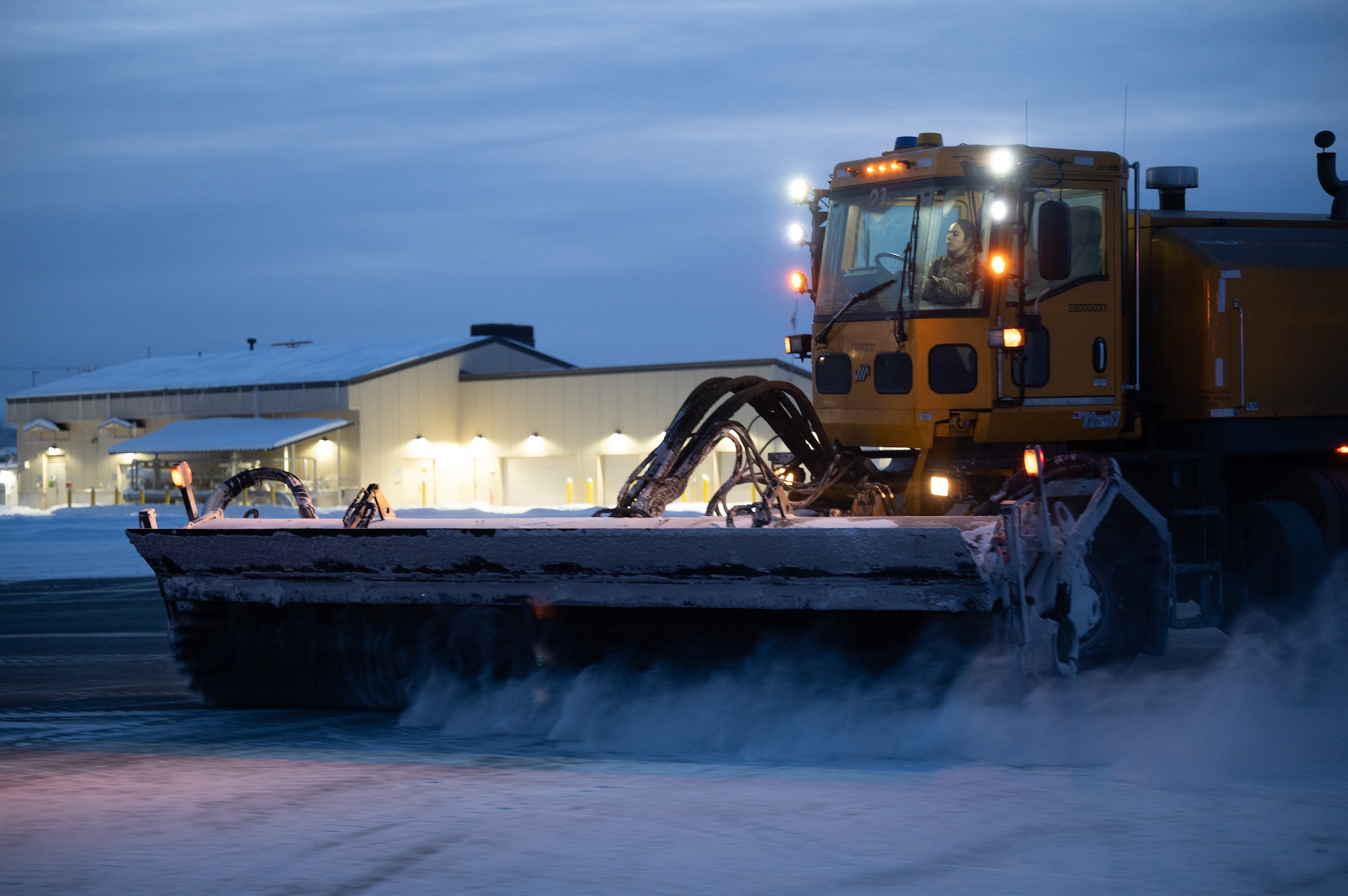U.S. Air Force Airman 1st Class Elizabeth Opell, 354th Civil Engineering Squadron pavement and equipment specialist, operates a snow broom on the flight line on Eielson Air Force Base, Alaska, Dec. 19, 2023. The snow brooms run 24/7 shifts to ensure the flight line is clear to deploy aircraft in support of Pacific Air Forces and United States Indo-Pacific Command missions. (U.S. Air Force photo by Airman Spencer Hanson)