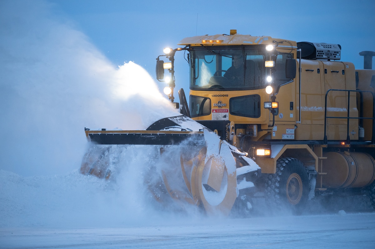 A 354th Civil Engineering Squadron snowplow operator blows snow off the flight line on Eielson Air Force Base Alaska, Dec. 19, 2023. The snowplow operators run 24/7 shifts to ensure the flightline is clear to deploy aircraft in support of Pacific Air Forces and United States Indo-Pacific Command missions. (U.S. Air Force photo by Airman Spencer Hanson)