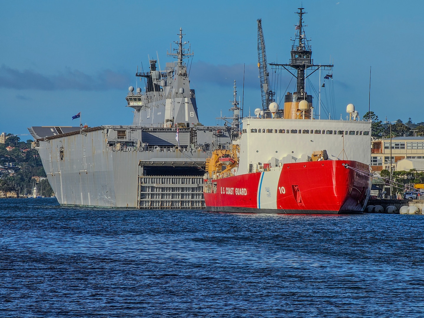 U.S. Coast Guard Cutter Polar Star (WAGB 10) is seen moored up next to HMAS Adelaide (L01) at HMAS Kuttabul, Sydney, Australia, Dec. 12, 2023. Operation Deep Freeze is one of many operations in the Indo-Pacific in which the U.S. military promotes security and stability across the region. (U.S. Coast Guard photo by Petty Officer 3rd Class Ryan Graves)