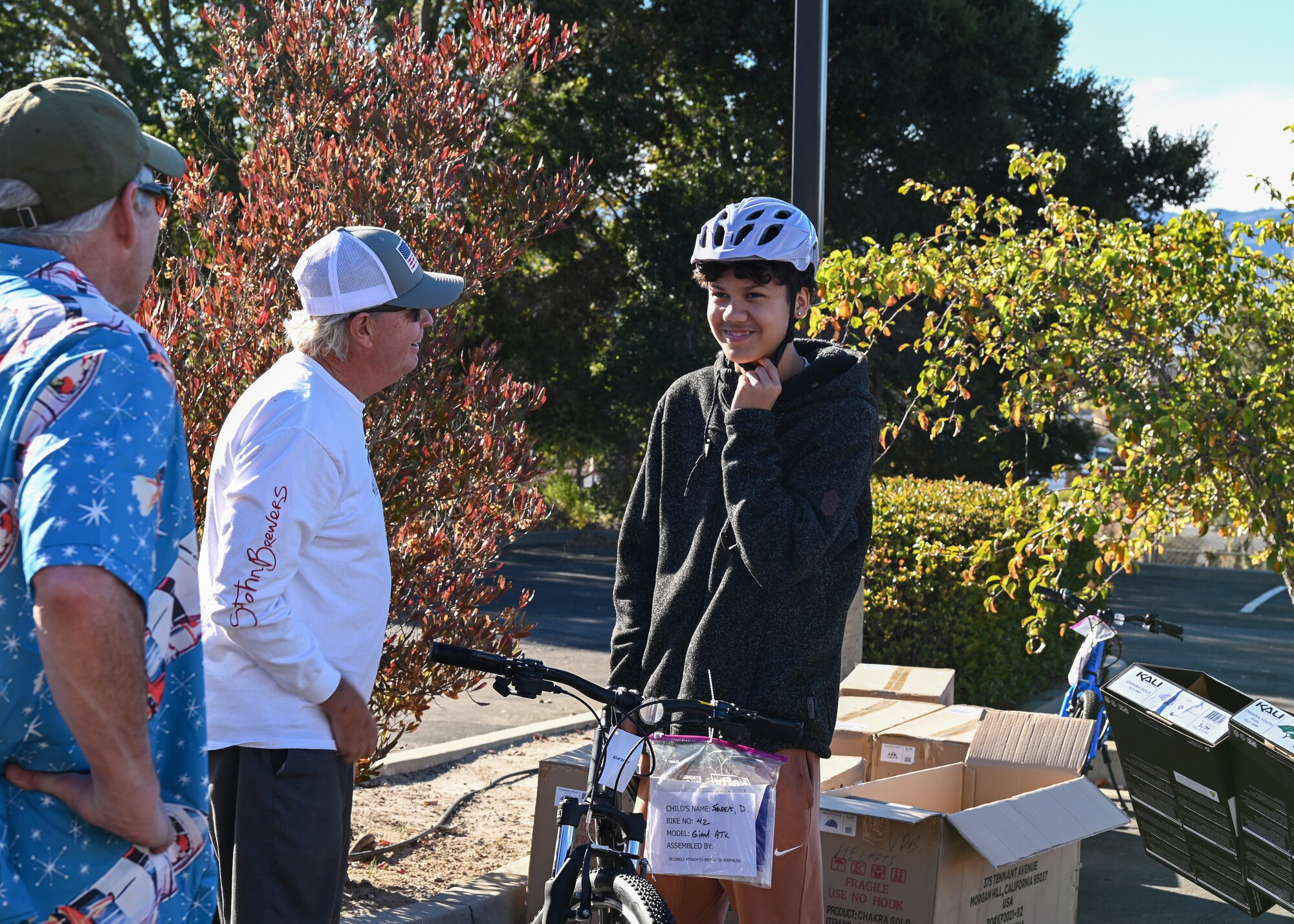 Members of the Village Dirtbags participate in helping children pick out their helmets during the Holiday Bike Give Away in Lompoc.