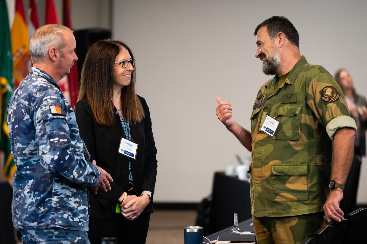Individuals standing in a conference room.