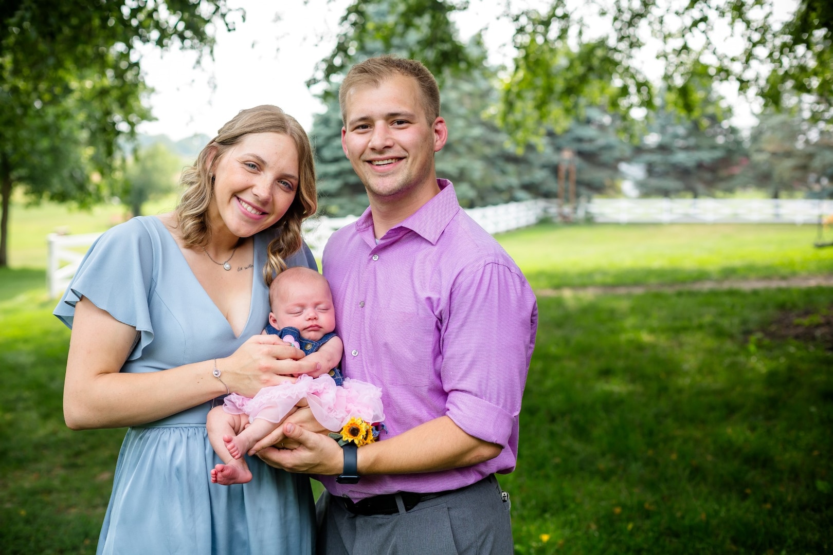 Spc. Becca Nikolas of the Minnesota National Guard and her husband hold their infant daughter.