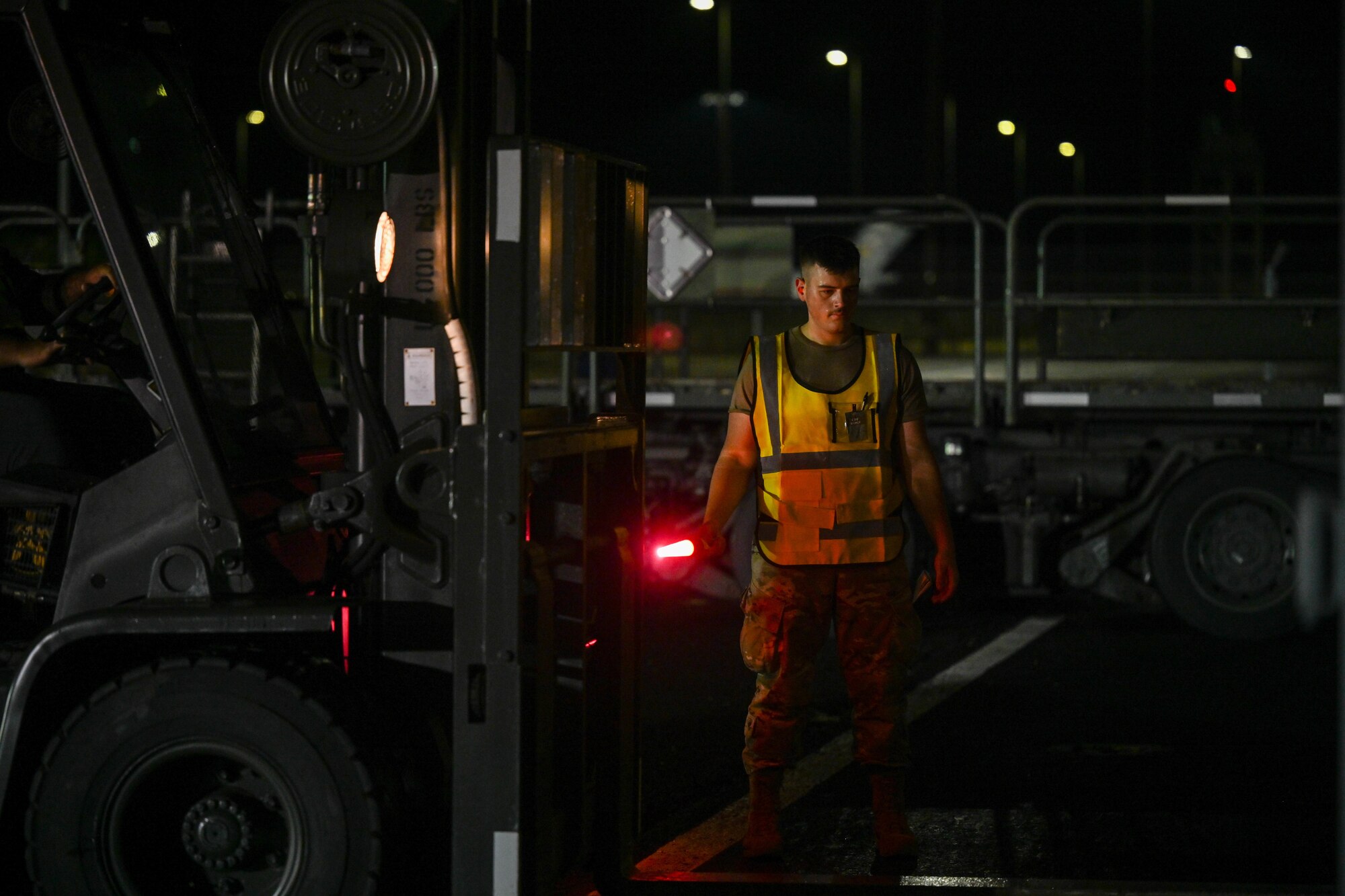 2nd. Lt. Shane Fillion, 647th Logistics Readiness Squadron, cargo deployment functional officer, directs a forklift, carrying cargo, onto a K-loader during the Readiness Exercise 24-01 at Joint Base Pearl Harbor-Hickam, Hawaii, Dec. 13, 2023. The 15th Wing trains to operate, fight and advance its capabilities through realistic training exercises designed to test and develop joint logistics, resilience and rapid strategic mobility. (U.S. Air Force photo by Senior Airman Makensie Cooper)