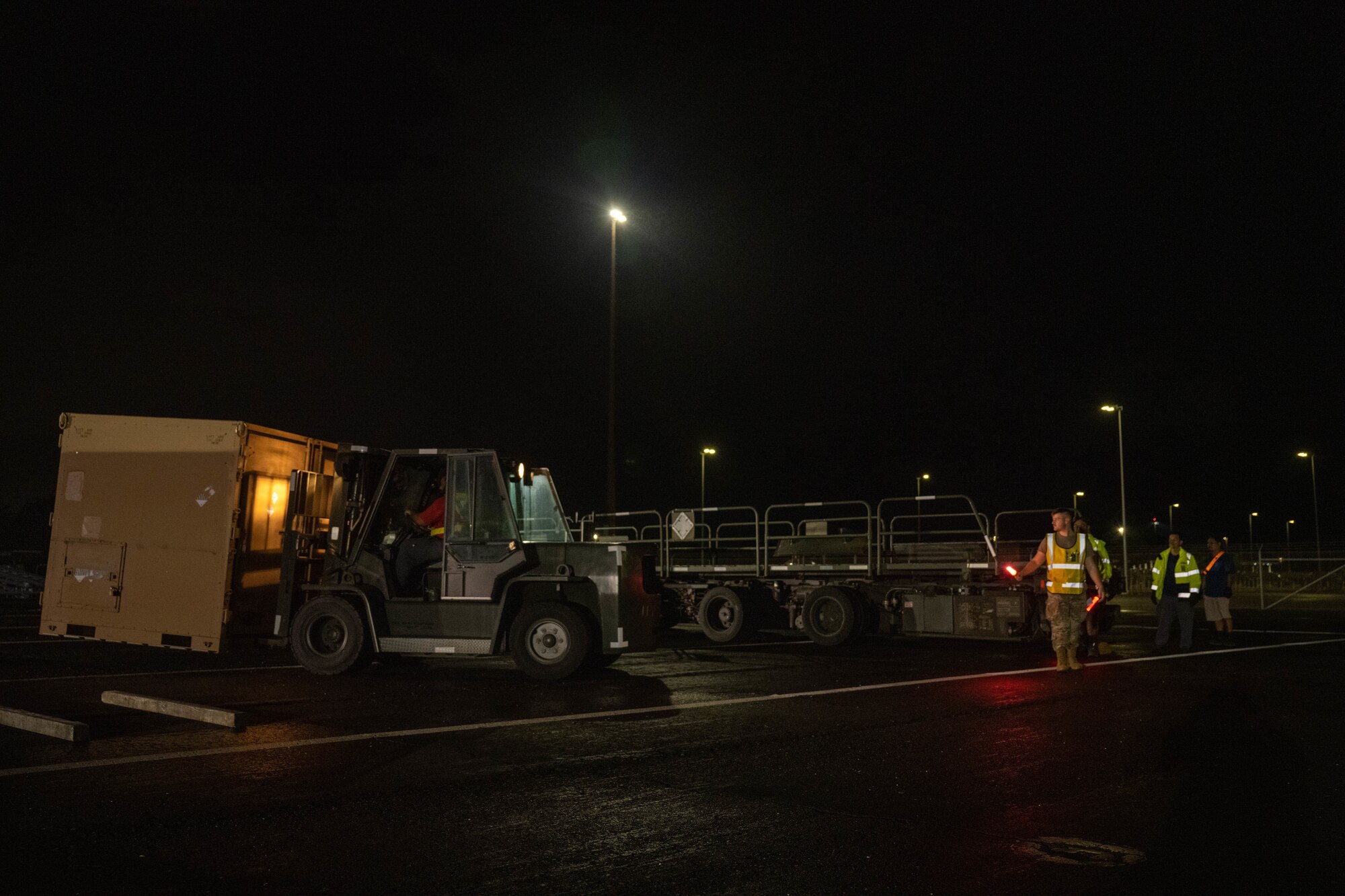 2nd. Lt. Shane Fillion, 647th Logistics Readiness Squadron, cargo deployment functional officer, directs a forklift carrying cargo onto a K-loader during the Readiness Exercise 24-01 at Joint Base Pearl Harbor-Hickam, Hawaii, Dec. 13, 2023. The RE provides realistic training in various operations, enabling our Airmen to provide distinct tools and capabilities needed for mission success in an ever-changing theater. (U.S. Air Force photo by Senior Airman Makensie Cooper)