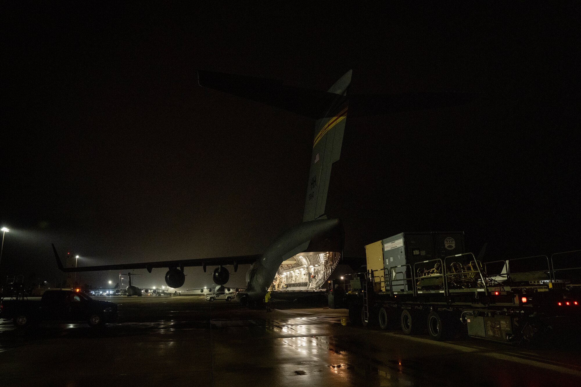 Airmen from the 15th Wing participate in the Readiness Exercise 24-01 loading cargo onto a C-17 Globemaster III at Joint Base Pearl Harbor Hickam, Hawaii, Dec. 13. 2023. The RE provides realistic training in various operations, enabling our Airmen to provide distinct tools and capabilities needed for mission success in an ever-changing theater. (U.S. Air Force photo by Senior Airman Makensie Cooper)