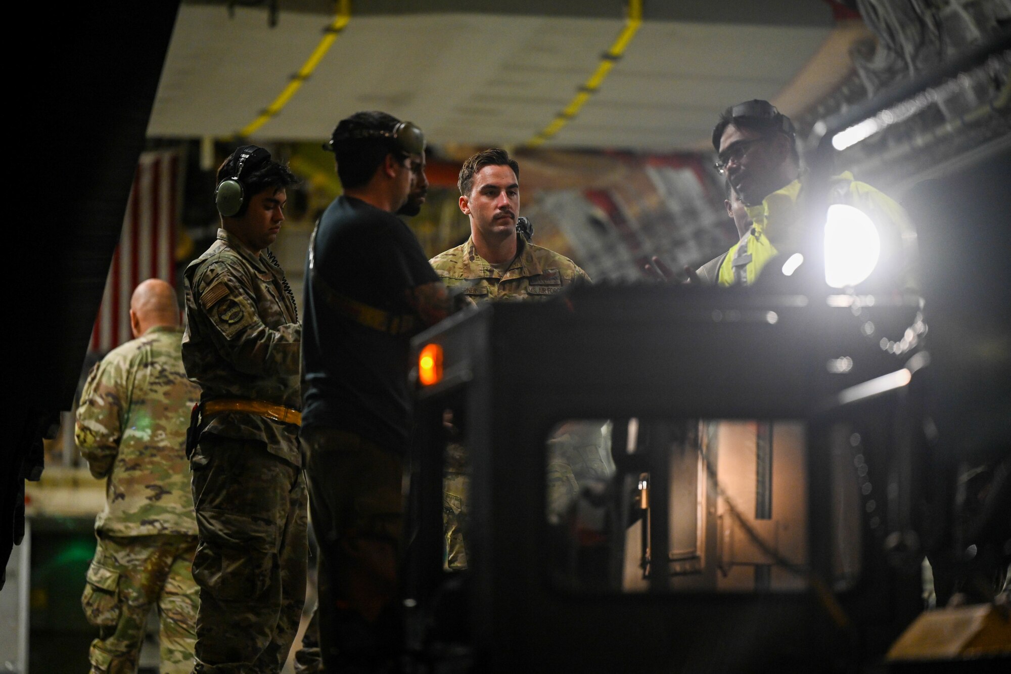 Airmen from the 535th Airlift Squadron and the 15th Maintenance Group prepare to load cargo onto a C-17 Globemaster III during the Readiness Exercise 24-01 at Joint Base Pearl Harbor-Hickam, Hawaii, Dec. 13, 2023. The 15th Wing trains to operate, fight and advance its capabilities through realistic training exercises designed to test and develop joint logistics, resilience and rapid strategic mobility. (U.S. Air Force photo by Senior Airman Makensie Cooper)