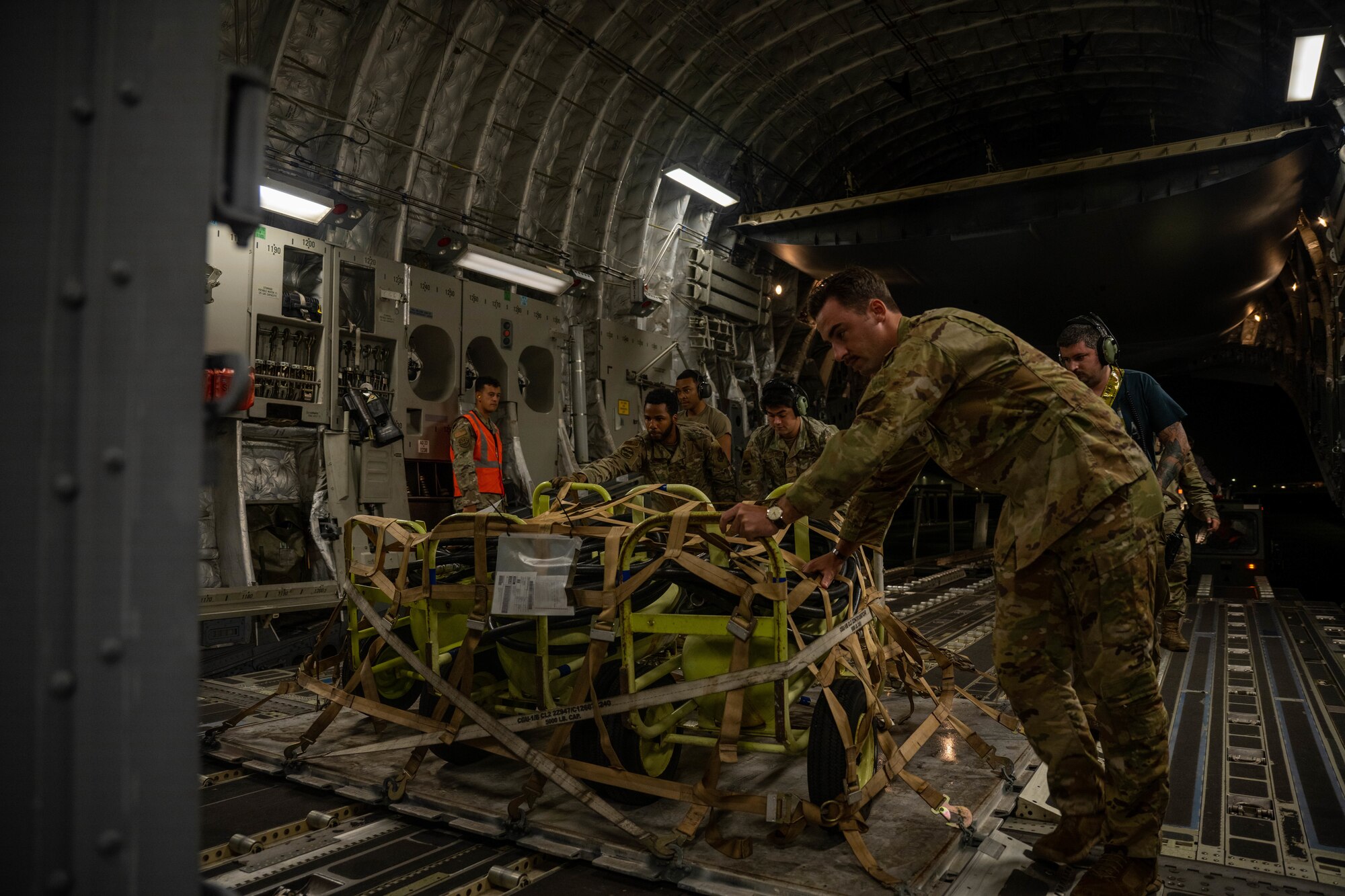 Airmen from the 535th Airlift Squadron and the 15th Maintenance Group load cargo onto a C-17 Globemaster III during the Readiness Exercise 24-01 at Joint Base Pearl Harbor-Hickam, Hawaii, Dec. 13, 2023. The RE provides realistic training in various operations, enabling our Airmen to provide distinct tools and capabilities needed for mission success in an ever-changing theater. (U.S. Air Force photo by Senior Airman Makensie Cooper)