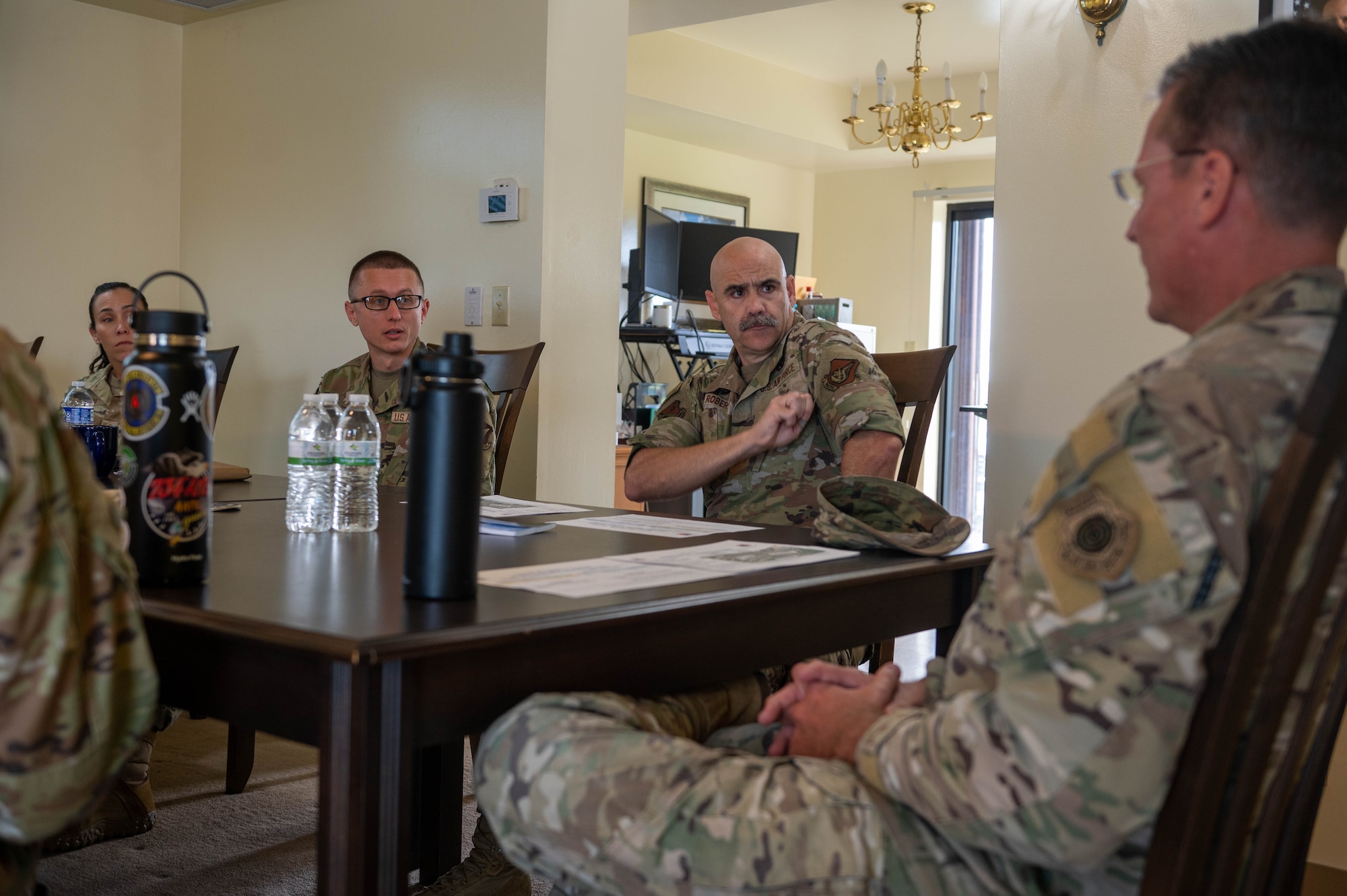 U.S. Air Force Col. Adam Roberts (middle), commander of the 356th Expeditionary Civil Engineer Group, attends a meeting with U.S. Air Force Brig. Gen. Thomas Palenske (right), commander of the 36th Wing, about rehabilitating Flemming Heights family housing at Andersen Air Force Base, Guam, Dec. 21, 2023. The 356th Expeditionary Civil Engineer Group is rehabilitating Flemming Heights family housing for office and billeting bed down as the primary hub location enabling theater construction efforts, Pacific Air Force exercise support, and agile combat employment concept of operations. (U.S. Air Force photo by Airman 1st Class Allon Lapaix)