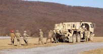 Soldiers prepare to recover a vehicle that is mired (stuck) in a sand pit. Regional training Site Maintenance – Fort Indiantown Gap, under the 94th Training Division, partnered with the 1st Brigade Combat Team 10th Mountain Division in Fort Drum, NY, to ensure 16 active-duty soldiers received the wheeled recovery specialist additional skill identifier.