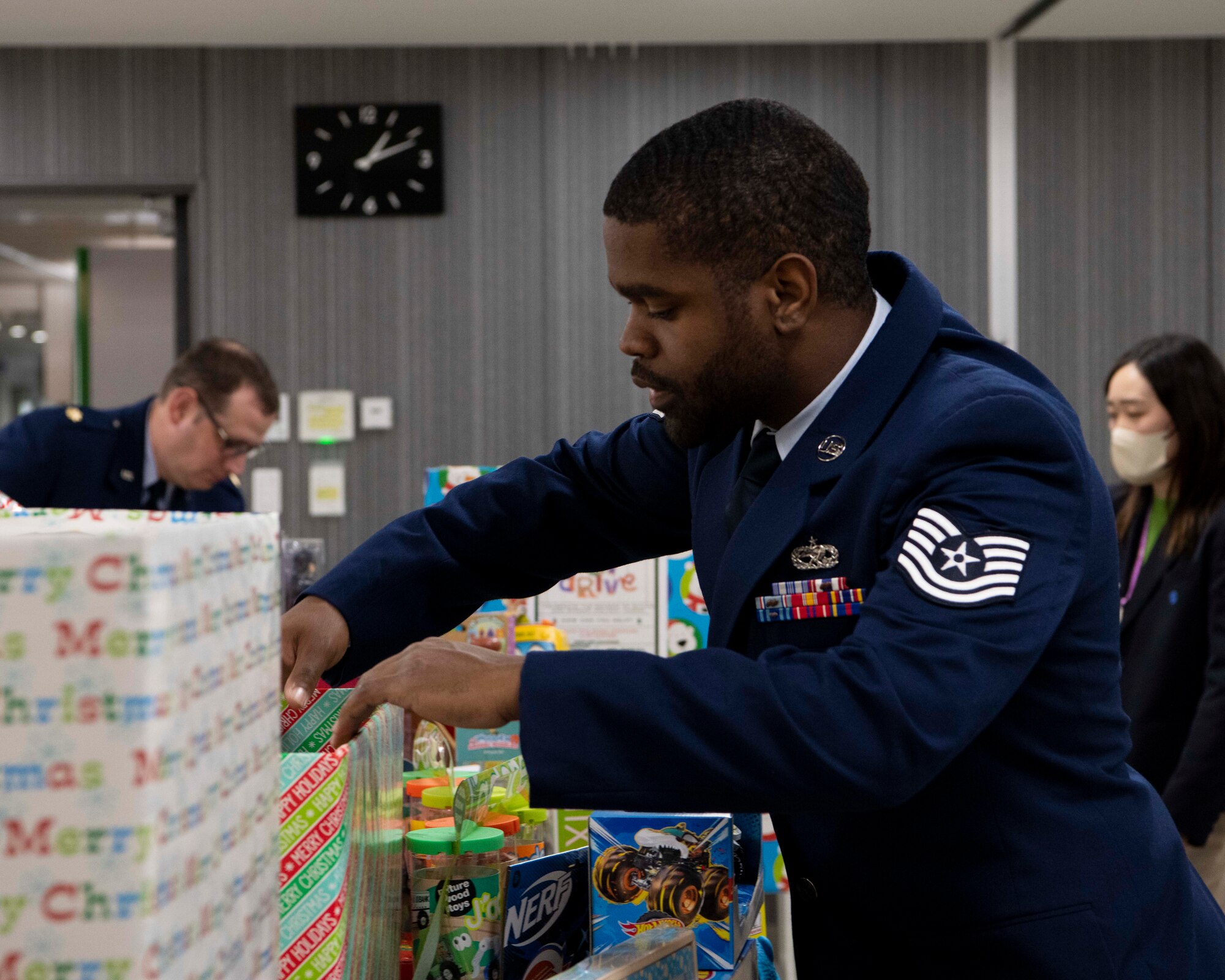 An Airman puts gifts on a table.