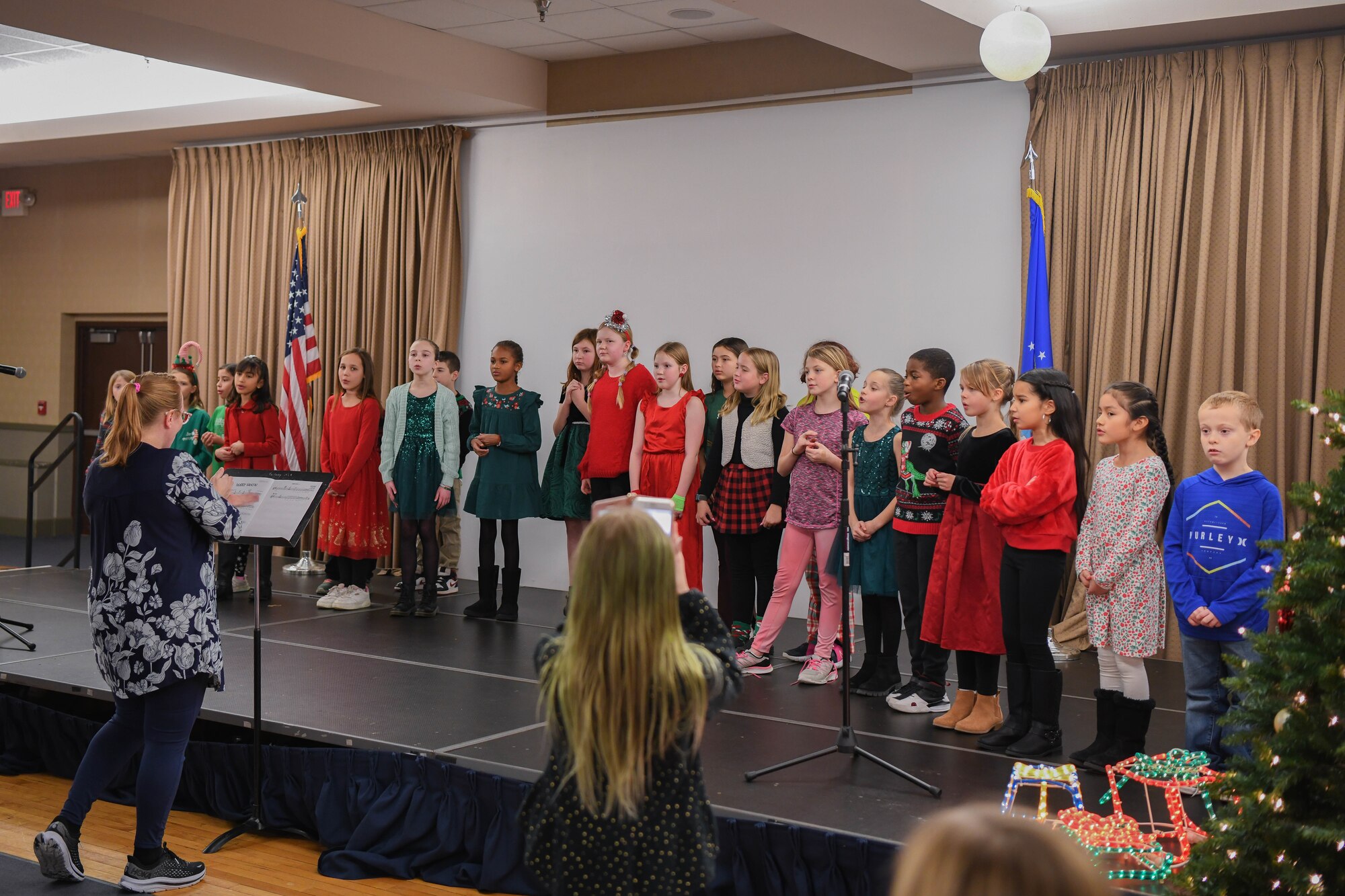 A kids choir sings carols while on stage.
