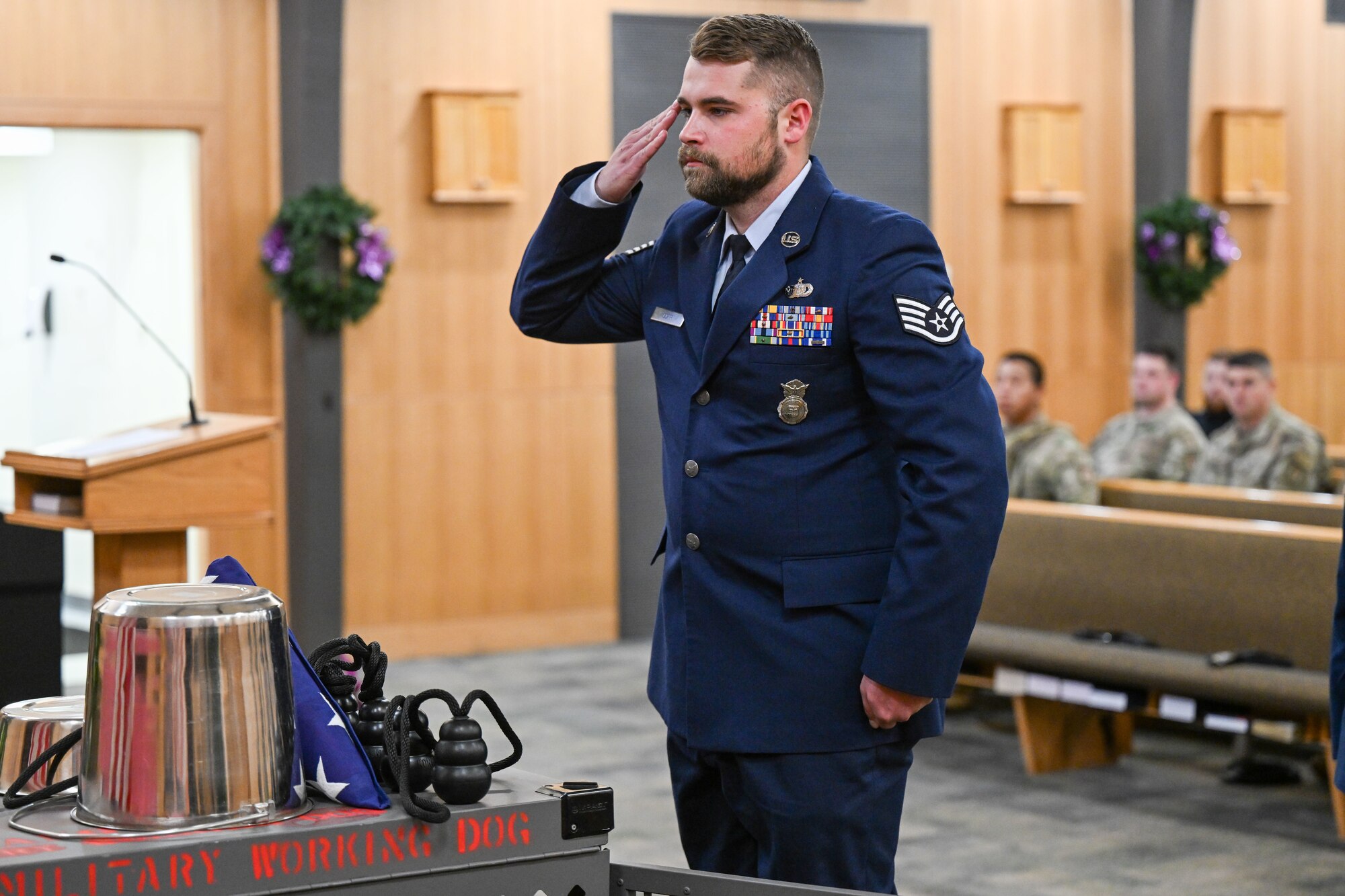 An Airman salutes the missing dog display during an MWD memorial.