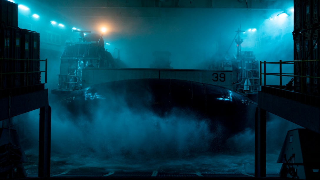 A U.S. Navy landing craft, air cushion assigned to Assault Craft Unit 5 transports 15th Marine Expeditionary Unit personnel and equipment aboard the amphibious assault ship USS Boxer (LHD 4) while underway in the Pacific Ocean, Dec. 7, 2023. The 15th MEU is currently embarked aboard the Boxer Amphibious Ready Group conducting integrated training and routine operations in U.S. 3rd Fleet. (U.S. Marine Corps photo by Cpl. Amelia Kang)