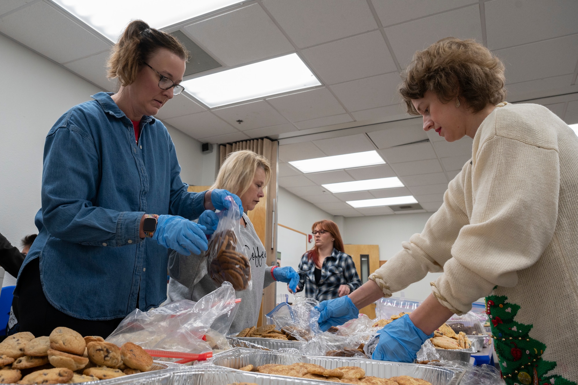 Volunteers for Operation Cookie Drop sort and box cookies at Dyess Air Force Base, Texas, Dec. 15, 2023. Hosted by the Dyess Spouses’ Club, the event collects home-made cookies to be delivered to 725 dorm Airmen. (U.S. Air Force photo by Airman 1st Class Alondra Cristobal Hernandez)