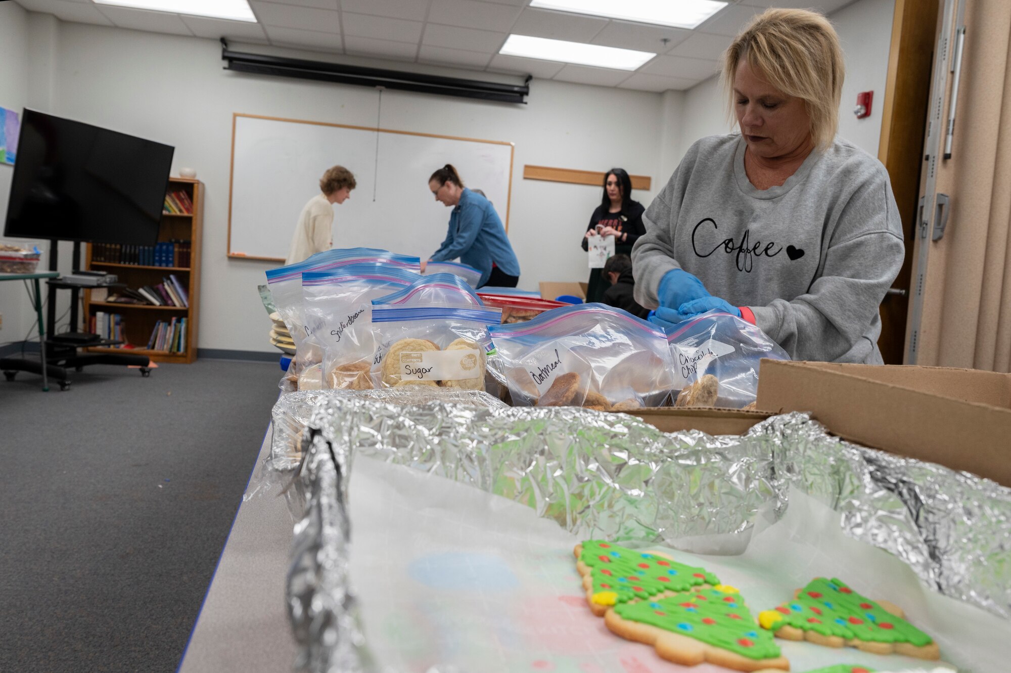 Volunteers for Operation Cookie Drop sort cookies into bags at Dyess Air Force Base, Texas, Dec. 18, 2023. The cookie drop drive is an annual event organized by the Spouses’ group, bringing holiday cheer to the Airmen in dorms. (U.S. Air Force photo by Airman 1st Class Alondra Cristobal Hernandez)
