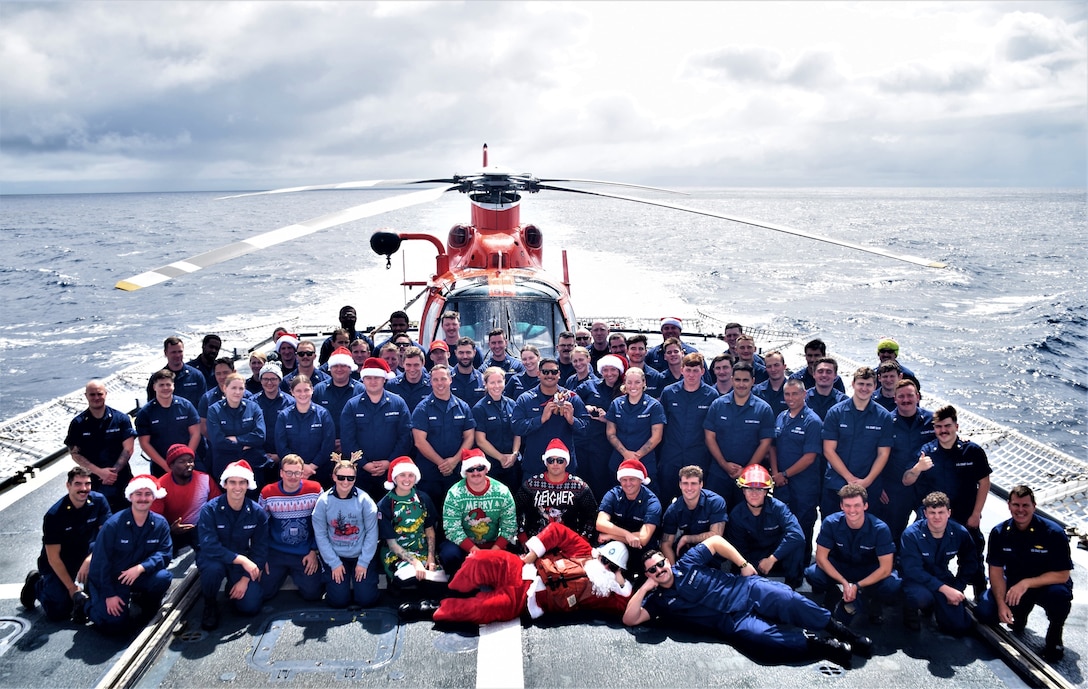 The crew of the U.S. Coast Guard Cutter Seneca (WMEC 906) poses for a group photo on the flight deck with a Helicopter Interdiction Tactical Squadron MH-65 helicopter and crew, Nov. 22, 2023, in the Eastern Pacific Ocean. Seneca deployed to the Eastern Pacific Ocean for maritime safety and security missions.