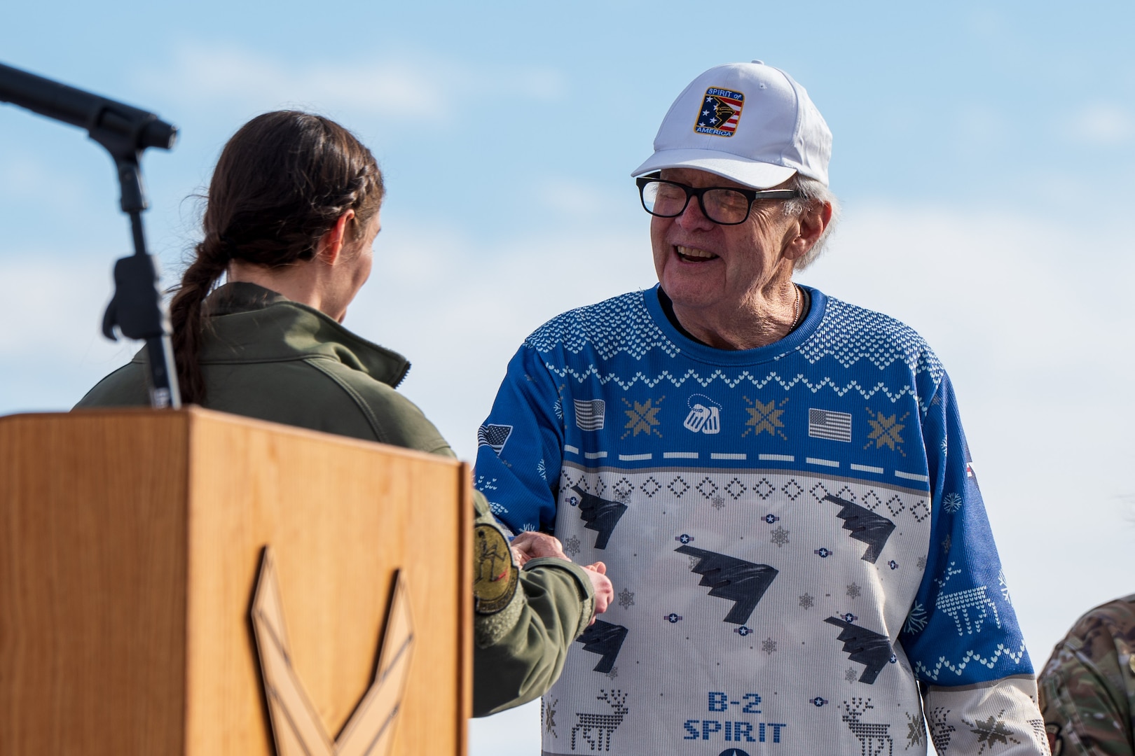 Retired U.S. Air Force Lt. Col. Bruce Hinds, B-2 Spirit test pilot, Spirit 1, shakes hands with Capt. Janel Campbell, 13th Bomb Squadron B-2 pilot, Spirit 823, as part of the 30th anniversary of B-2’s at Whiteman Air Force Base, Mo., Dec. 15, 2023. In 1982, Hinds retired from the Air Force and went to work as the chief test pilot on the Advanced Technology Bomber program which led to him becoming Spirit 1. (U.S. Air Force photo by Airman 1st Class Robert E. Hicks)