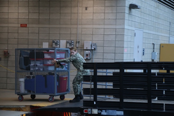 Sailors from Naval Health Clinic Lemoore load point of dispensary (POD) units onto a flatbed truck to transport the shot exercise location at the Flight Readiness Center (FRC) West aboard Naval Air Station (NAS) Lemoore.