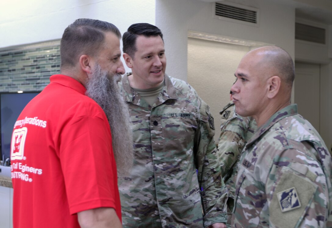 Kansas City District emergency management specialist Rick Weixelbaum chats with Honolulu District Commander Lt. Col. Ryan Pevey and Pacific Ocean Division Command Sgt. Maj. Jaime Lopez Dec.20 at the Hawaii Wildfires mission emergency field office. Weixelbaum is deployed to Lahina, Maui as a debris specialist for the combined federal, state, and local wildfires recovery mission. Pevey and Lopez visited deployed personnel who will not be home for the holidays to thank them for their service to the mission.