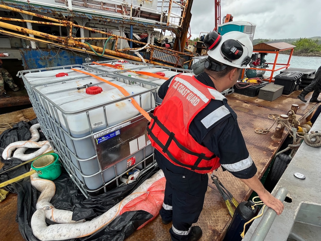 A member of the U.S. Coast Guard oversees an environmental services team responding to the grounding of the motor vessel Voyager, a 116-foot Indonesian-flagged ship adjacent to Piti Channel following Typhoon Mawar in Piti, Guam, in August 2023. By late November, the operation successfully recovered approximately 51,000 gallons of fuel oil mixture, around four cubic yards of oiled debris, and various hazardous substances from the M/V Voyager, prioritizing environmental safety and the likelihood of operational success. (U.S. Coast Guard photo)