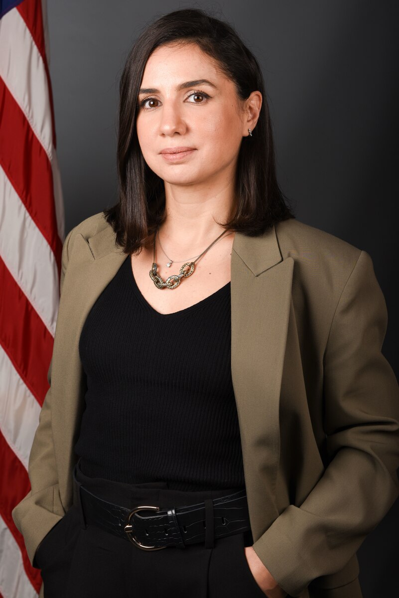 A Woman stands confidently with her hands in her pockets