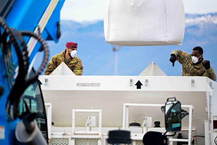 U.S. Air Force Senior Airman Jommo Gathara, 31st Civil Engineer Squadron structural journeyman, and Italian army personnel direct a telehandler forklift during a training exercise.